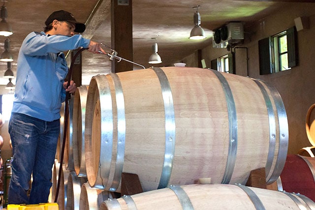 Topping off a wine barrel